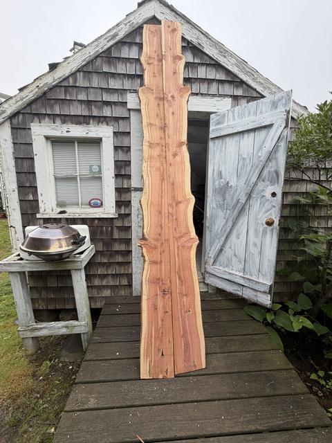 Island cedar, live edge and all, waiting its turn at the shack door.