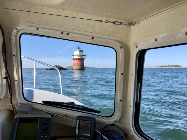 A lighthouse through the wheelhouse window.
