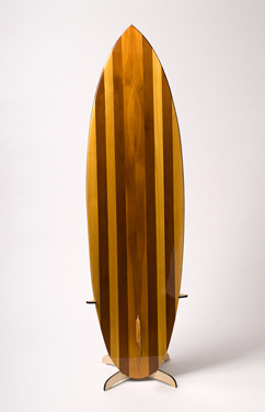 A striped hollow wooden surfboard standing upright on its display stand, seen from the back